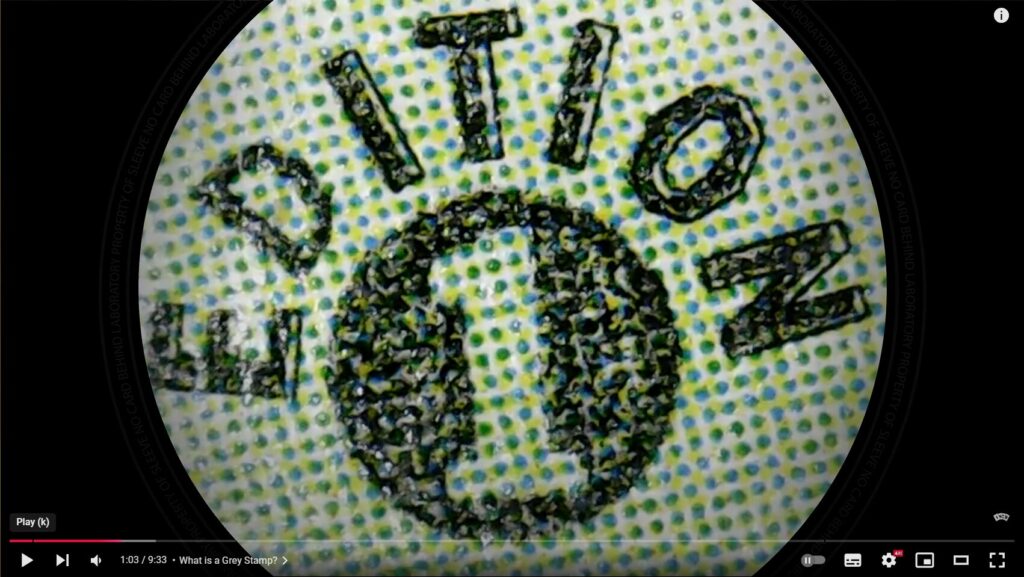 grey 1st edition stamp under a microscope